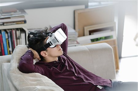 simsearch:649-08702598,k - Young man on sofa wearing virtual reality headset Stock Photo - Premium Royalty-Free, Code: 649-08702598