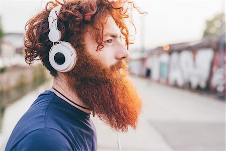 simsearch:649-07560167,k - Young male hipster with red hair and beard listening to headphones in city Photographie de stock - Premium Libres de Droits, Code: 649-08702675