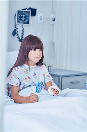 Girl patient with arm plaster cast  in bed with lollipop in hospital children's ward Photographie de stock - Premium Libres de Droits, Code: 649-08702709