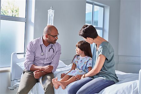 Male doctor talking to girl patient and her mother in hospital children's ward Foto de stock - Sin royalties Premium, Código: 649-08702715