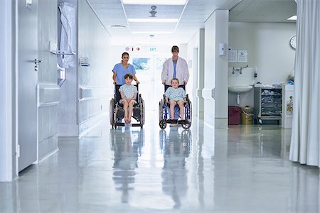 Medical orderly pushing boy patients in wheelchair  on hospital children's ward Stockbilder - Premium RF Lizenzfrei, Bildnummer: 649-08702729