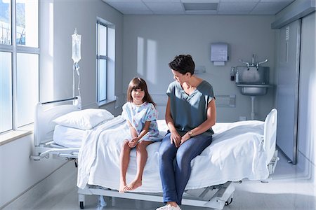 smiling kids in hospital - Girl patient and her mother sitting on bed in hospital children's ward Stock Photo - Premium Royalty-Free, Code: 649-08702734