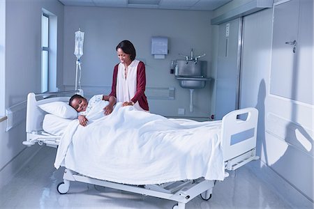 Girl patient in bed tended by her mother on hospital children's ward Stock Photo - Premium Royalty-Free, Code: 649-08702739