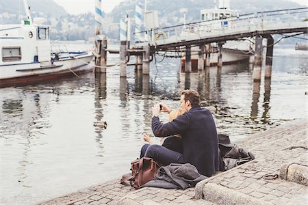 simsearch:649-08702811,k - Young couple sitting photographing from lakeside, Lake Como, Italy Fotografie stock - Premium Royalty-Free, Codice: 649-08702778