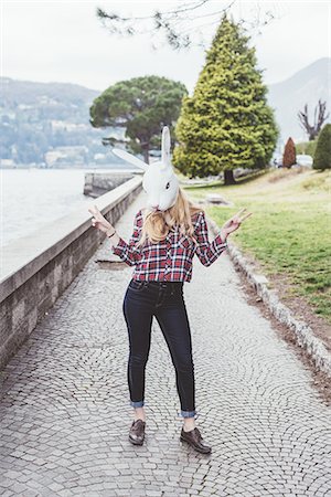 símbolo de paz - Portrait of woman wearing rabbit mask making peace sign, Lake Como, Italy Foto de stock - Royalty Free Premium, Número: 649-08702802