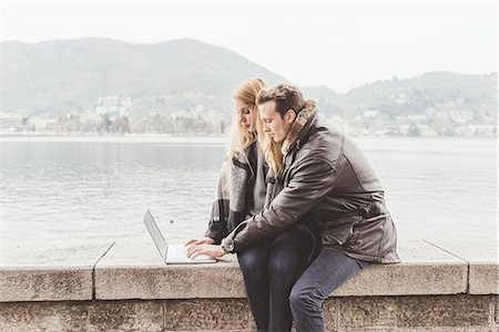 simsearch:649-09269104,k - Young couple typing on laptop on harbour wall, Lake Como, Italy Stock Photo - Premium Royalty-Free, Code: 649-08702813