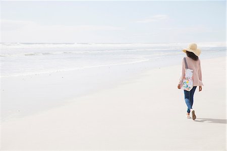 simsearch:649-07803258,k - Young woman walking on beach Photographie de stock - Premium Libres de Droits, Code: 649-08702952