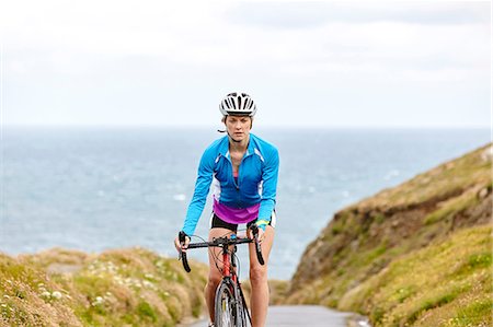 fahrradhelm - Cyclist riding on road overlooking ocean Stockbilder - Premium RF Lizenzfrei, Bildnummer: 649-08703040