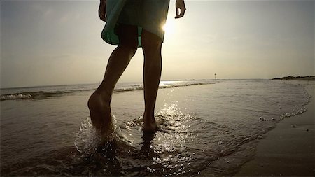 Legs of woman on coastline walking in ocean Stock Photo - Premium Royalty-Free, Code: 649-08703165