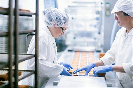 person in a food factory in hair net - Factory workers on food production line Photographie de stock - Premium Libres de Droits, Code: 649-08703175