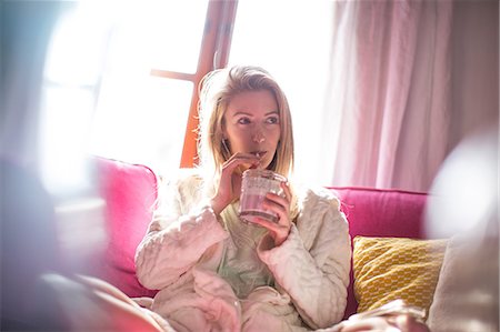 person drinking smoothie - Young woman relaxing on sofa drinking smoothie Stock Photo - Premium Royalty-Free, Code: 649-08703270