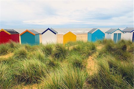 Rear view of a row multi-coloured beach huts in sand dunes, Southwold, Suffolk, UK Fotografie stock - Premium Royalty-Free, Codice: 649-08703361