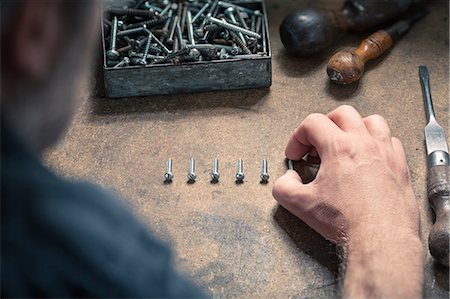 simsearch:6118-07354015,k - Man arranging screws of similar size in a row Foto de stock - Sin royalties Premium, Código: 649-08703427