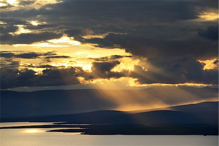 Silhouetted mountains and sun rays over Lake Imandra, Khibiny mountains, Kola Peninsula, Russia Photographie de stock - Premium Libres de Droits, Code: 649-08703450