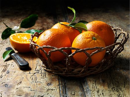 simsearch:649-06352854,k - Oranges in basket with one halved in background, rustic wooden table Stock Photo - Premium Royalty-Free, Code: 649-08703506