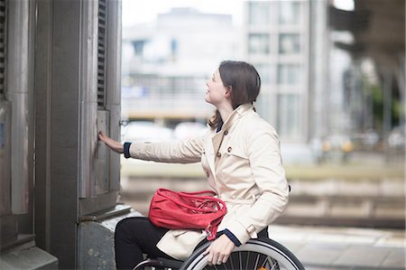 simsearch:649-05658446,k - Young woman using wheelchair pressing control for city elevator Photographie de stock - Premium Libres de Droits, Code: 649-08703583