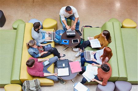 ethnically diverse college student studying with laptops or computers - Overhead view of seven male and female students brainstorming in higher education college study space Stock Photo - Premium Royalty-Free, Code: 649-08714109