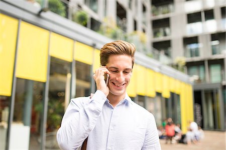 Young businessman talking on smartphone outside office, London, UK Stock Photo - Premium Royalty-Free, Code: 649-08714207