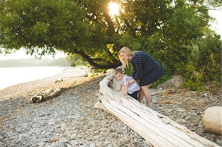 Boy with mother climbing onto tree trunk at Lake Ontario, Oshawa, Canada Stockbilder - Premium RF Lizenzfrei, Bildnummer: 649-08714275