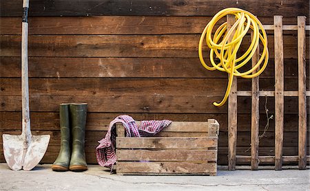 simsearch:649-06717497,k - Row of spade, rubber boots and hosepipe by shed Stock Photo - Premium Royalty-Free, Code: 649-08714327