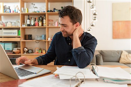 pressure of study - Man with laptop looking at paperwork Stock Photo - Premium Royalty-Free, Code: 649-08714487