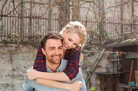 piggyback trust adults - Man giving woman piggyback smiling Stock Photo - Premium Royalty-Free, Code: 649-08714491