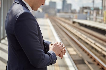 simsearch:649-08714633,k - Cropped shot of businessman checking watch at train platform, London, UK Photographie de stock - Premium Libres de Droits, Code: 649-08714626