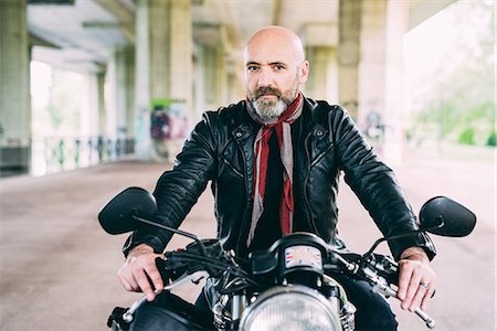 Portrait of mature male motorcyclist sitting on motorcycle under flyover Photographie de stock - Premium Libres de Droits, Code: 649-08714702