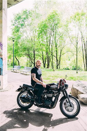 Portrait of mature male motorcyclist sitting on motorcycle Photographie de stock - Premium Libres de Droits, Code: 649-08714713