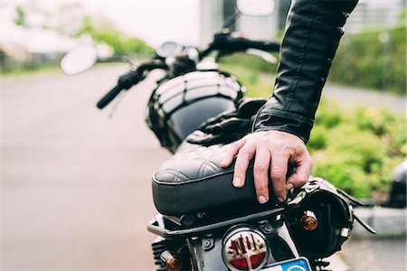 Hand of male motorcyclist leaning on motorcycle Stock Photo - Premium Royalty-Free, Code: 649-08714731