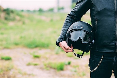 Mid section of male motorcyclist standing on wasteland holding helmet Photographie de stock - Premium Libres de Droits, Code: 649-08714744