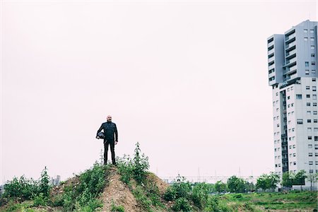 simsearch:649-08714749,k - Portrait of male motorcyclist standing on top of wasteland hill Foto de stock - Sin royalties Premium, Código: 649-08714745