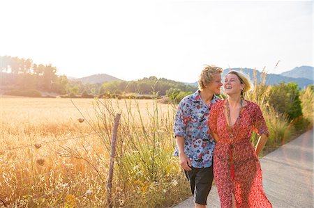 simsearch:649-08577651,k - Young couple laughing whilst strolling along rural road, Majorca, Spain Stock Photo - Premium Royalty-Free, Code: 649-08714771
