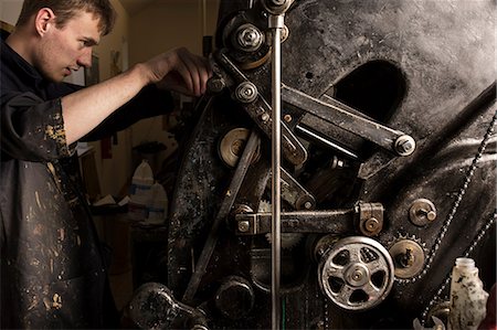 precision work - Young male printer operating printing machinery in printing press workshop Stock Photo - Premium Royalty-Free, Code: 649-08714906