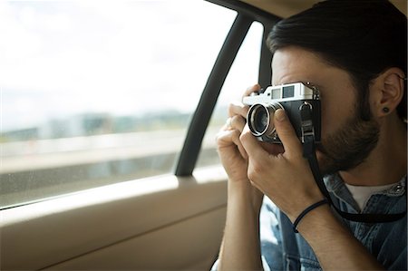 simsearch:614-06895809,k - Young man on the road, taking photographs through car window Photographie de stock - Premium Libres de Droits, Code: 649-08714924