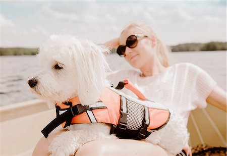Coton de tulear dog sitting on woman's lap in boat, Orivesi, Finland Stock Photo - Premium Royalty-Free, Code: 649-08714970
