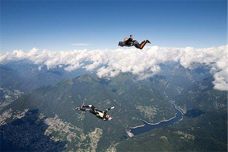 extreme sports and connect - Freestyle skydiving team training together. One man  performing air-ballet, another jumper is filming with video camera on helmet, Locarno, Tessin, Switzerland Stock Photo - Premium Royalty-Free, Code: 649-08714984