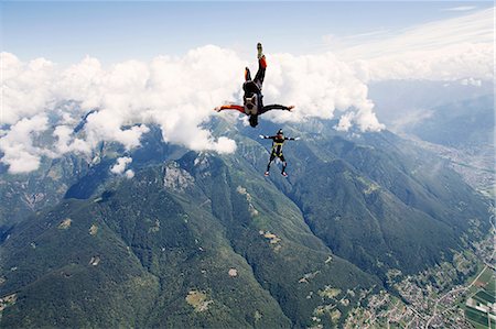 skydiver - Freestyle skydiving team training together. One man  performing air-ballet, another jumper is filming with video camera on helmet, Locarno, Tessin, Switzerland Stock Photo - Premium Royalty-Free, Code: 649-08714985