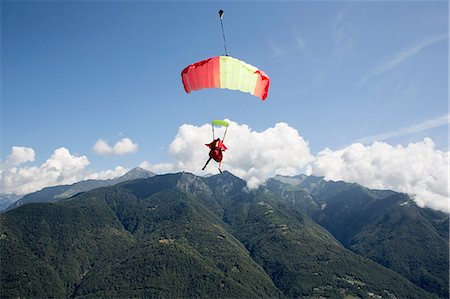 Skydiver under her parachute flying free in the blue sky, Locarno, Tessin, Switzerland Stock Photo - Premium Royalty-Free, Code: 649-08714988