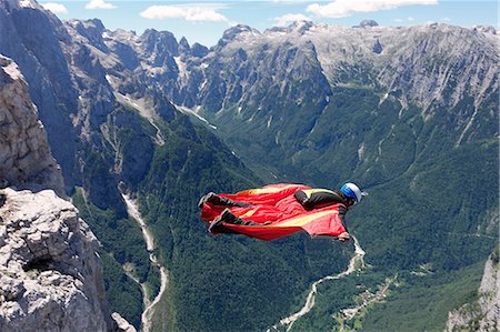 simsearch:649-08714984,k - Wingsuit BASE jumper flying along cliff side and down the valley, Italian Alps, Alleghe, Belluno, Italy Stock Photo - Premium Royalty-Free, Code: 649-08715006