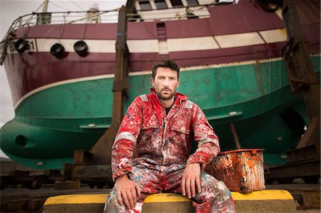 fishing boats scotland - Portrait of male ship painter sitting in front of fishing boat on drydock Stock Photo - Premium Royalty-Free, Code: 649-08715023