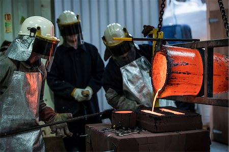 simsearch:649-08715047,k - Male foundry workers pouring bronze melting pot in bronze foundry Stock Photo - Premium Royalty-Free, Code: 649-08715047