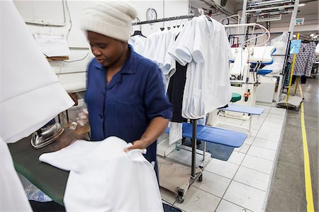 Worker ironing shirt in garment factory Foto de stock - Sin royalties Premium, Código: 649-08744856