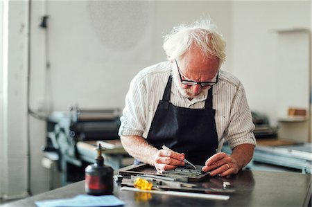 Senior craftsman working on letterpress in print workshop Stock Photo - Premium Royalty-Free, Code: 649-08744921