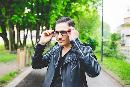 spectacles photography - Man adjusting spectacles in park Stock Photo - Premium Royalty-Free, Code: 649-08745001