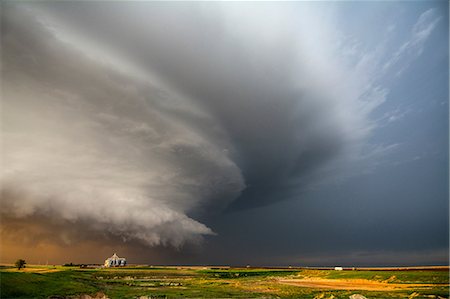 sobrecogimiento - A tornado-producing supercell thunderstorm spinning over ranch land at sunset near Leoti, Kansas Foto de stock - Sin royalties Premium, Código: 649-08745102