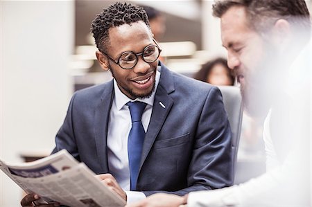 Two businessmen reading newspaper in office Stock Photo - Premium Royalty-Free, Code: 649-08745316