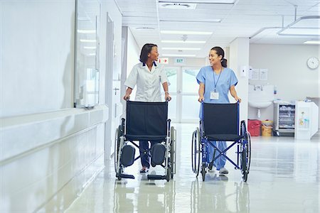 paarl - Female orderlies pushing wheelchairs along hospital corridor Stock Photo - Premium Royalty-Free, Code: 649-08745349