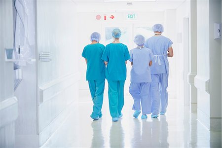 paarl - Rear view of four medical staff wearing scrubs walking in hospital corridor Stock Photo - Premium Royalty-Free, Code: 649-08745370