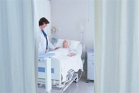 doctor and senior patient talking - Female doctor talking to senior female patient in hospital bed Stock Photo - Premium Royalty-Free, Code: 649-08745398